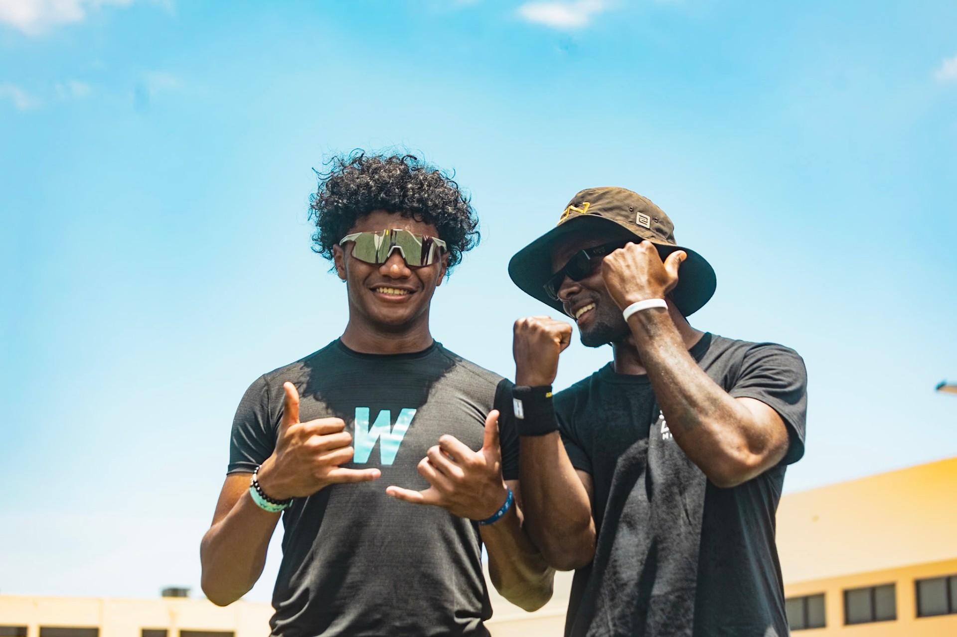 WeTrain trainer and young athlete throwing up shakas at the youth football camp