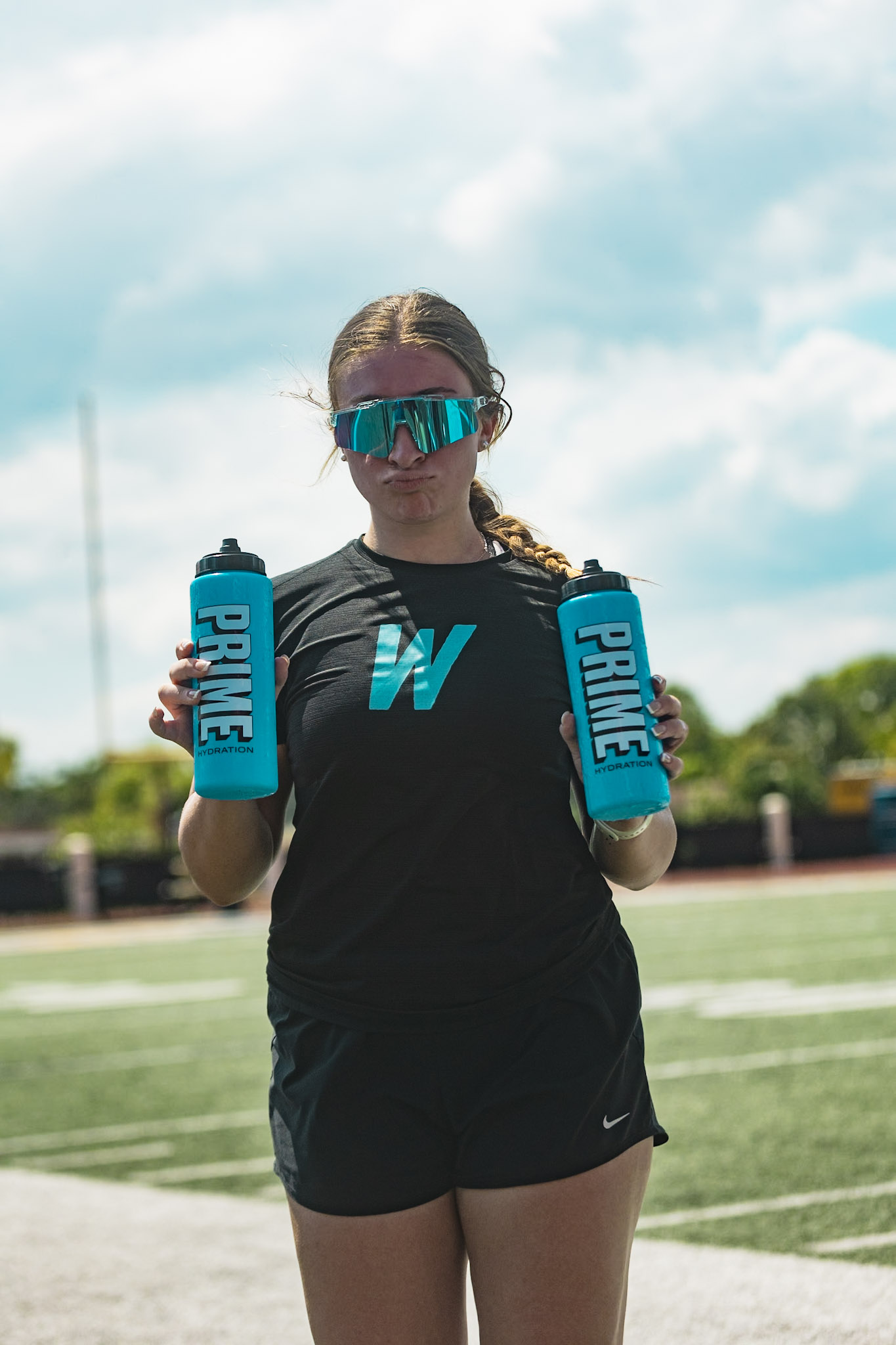 Athlete in a WeTrain tee hydrating during a camp break