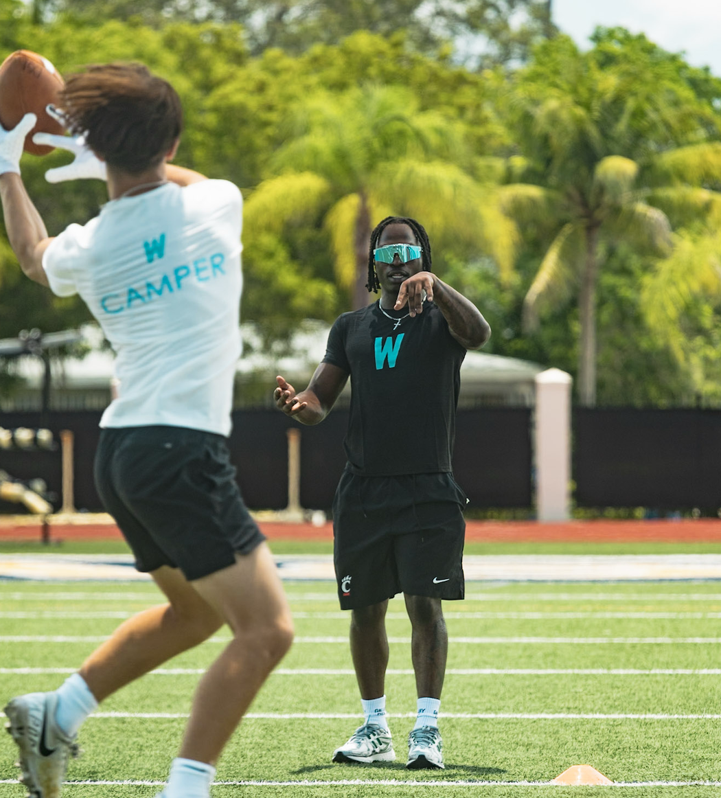 A WeTrain trainer coaching a young athlete during a youth football camp