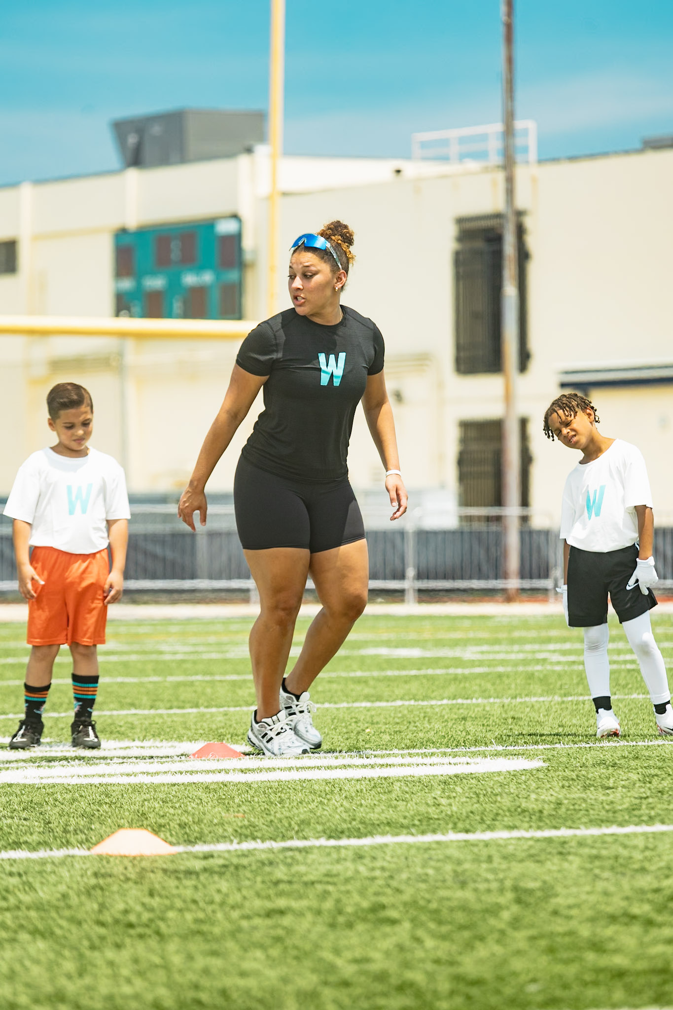 WeTrain trainer leading warmups with young athletes on the field