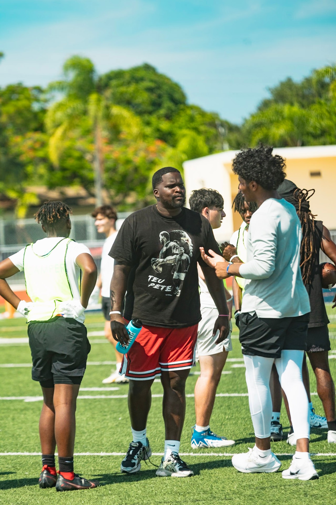 Peter Luton on the field with campers at WeTrain youth camp